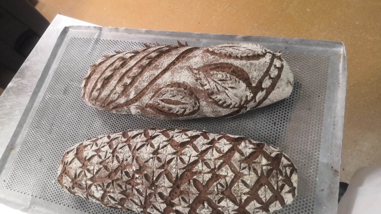 Two artisan loaves with decorative scoring